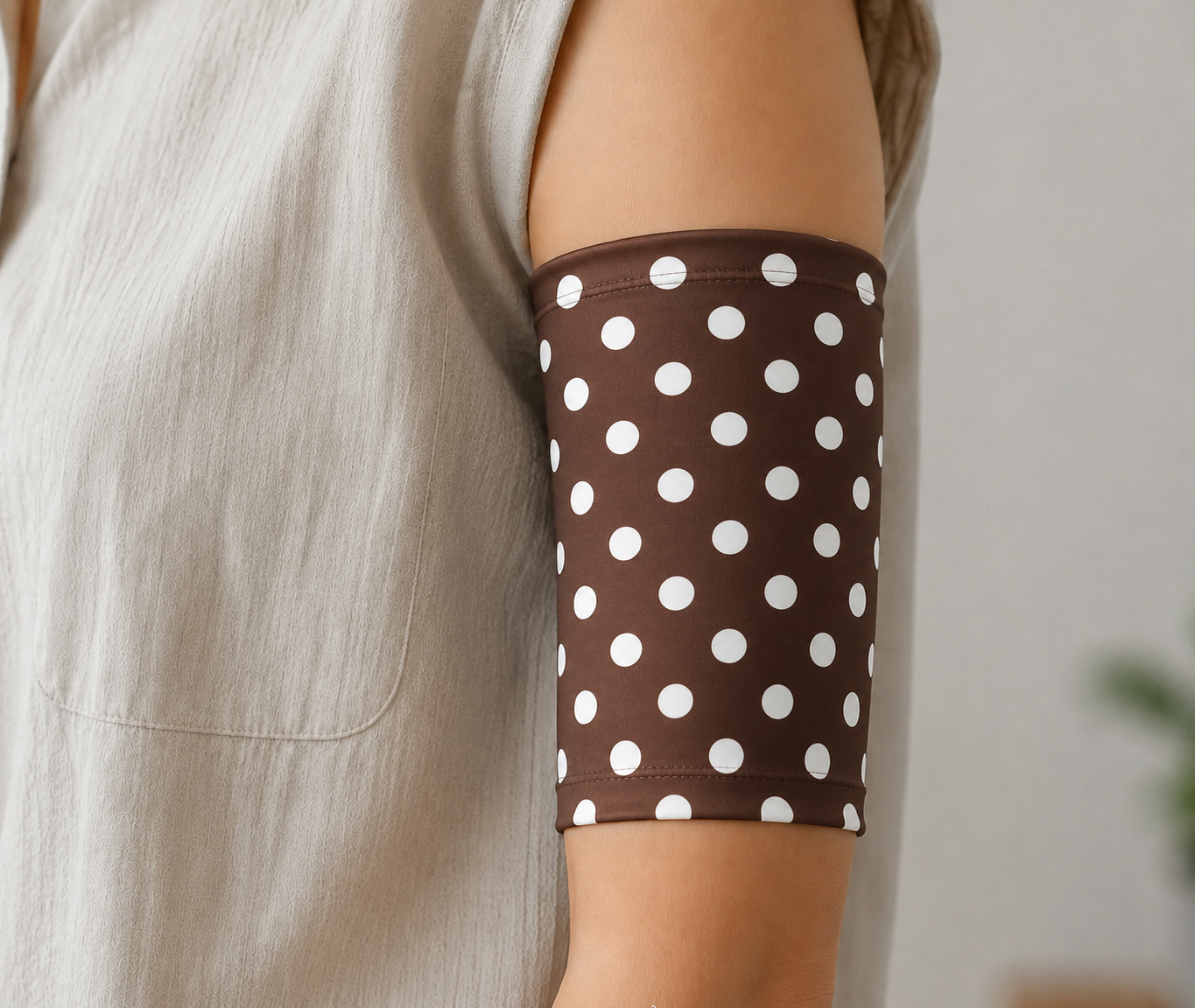 Brown piccline or midline cover with white polka dots worn by a person in a neutral setting
